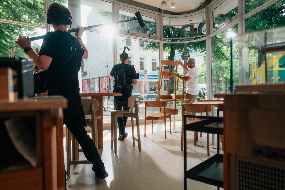 Dreh in einem Café, Tonangel und Kamera-Operator bei der Arbeit